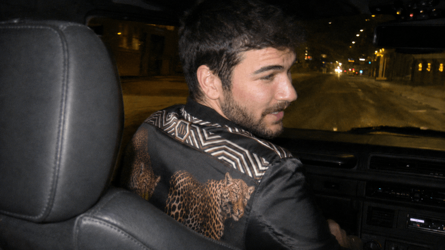 AI-generated night drive, a man in an embroidered jacket in the back seat