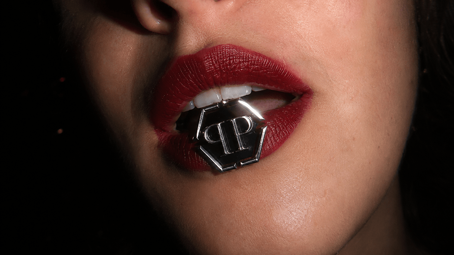 AI-generated close-up of red lips biting the hexagonal brand emblem