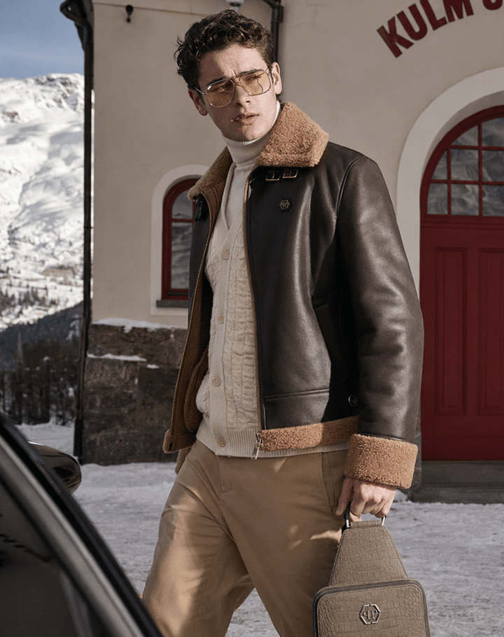 AI-generated editorial of a man in a shearling aviator jacket carrying a crossbody bag outside the Kulm